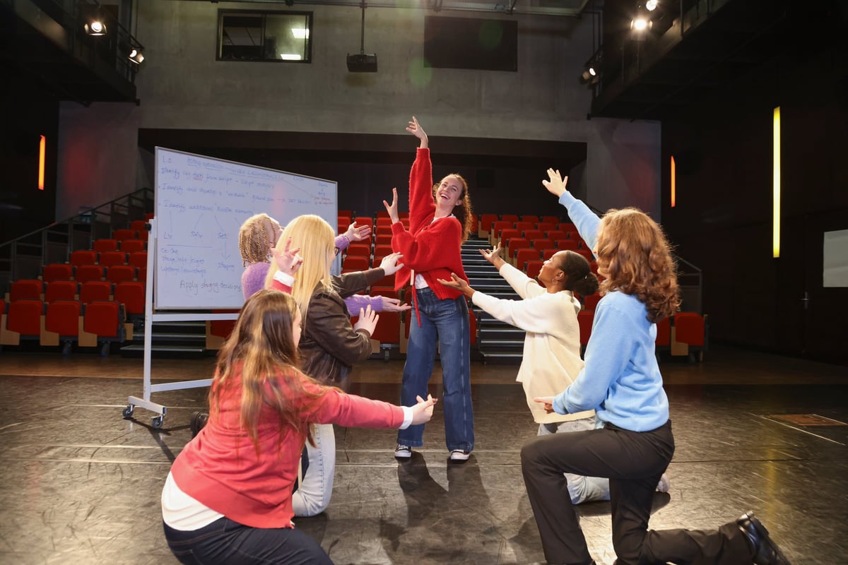 Group of smiling people with various disabilities rehearsing on stage